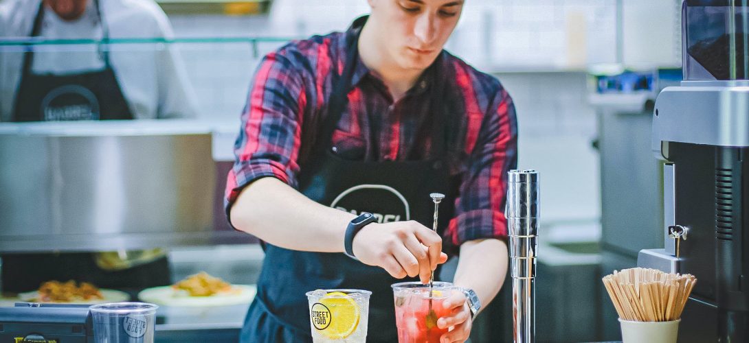 Bilden visar en person i ett kök med rostfri köksinredning. Hitta enkelt den bästa restaurangutrustningen hos en köksleverantör online.